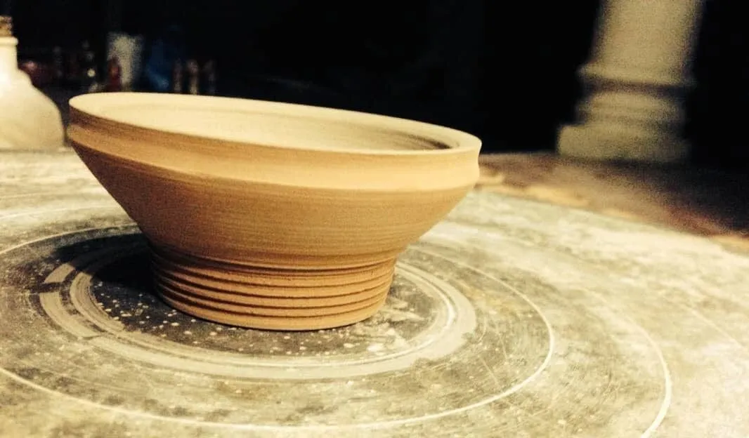 A freshly thrown bowl on the potter’s wheel