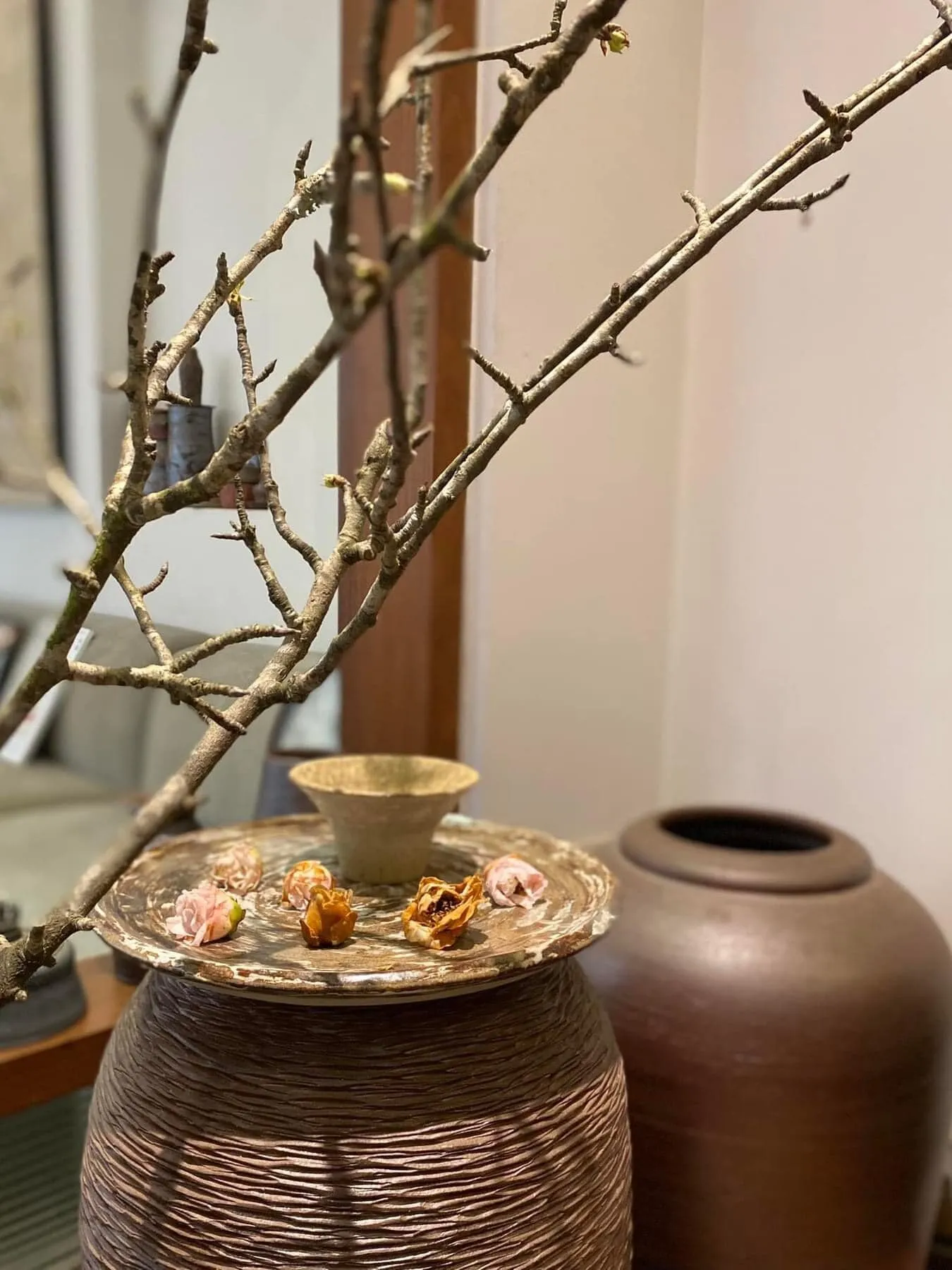 Large textured jars with a branch arrangement and dried flowers