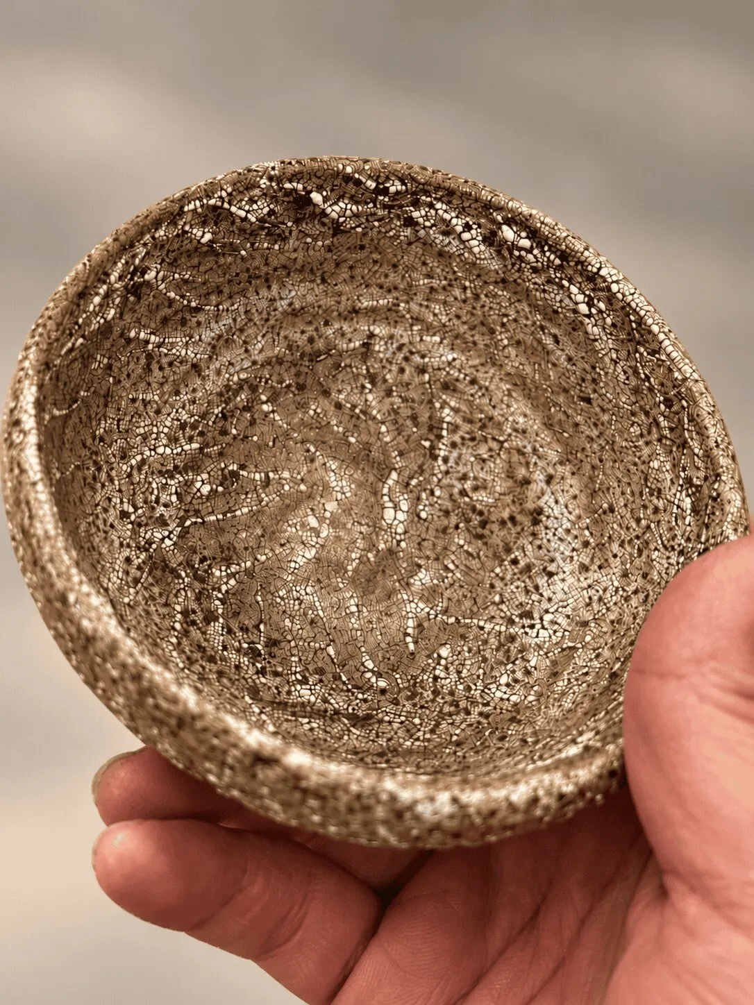 A small speckled bowl held in an open hand
