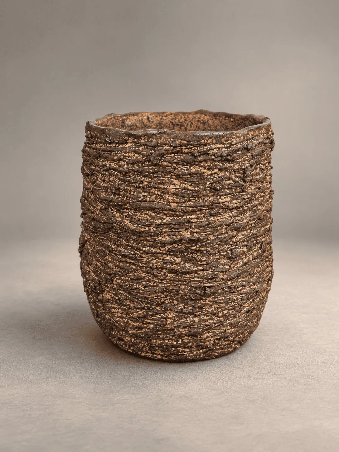 A cup with a coarse, layered texture like woven fibre